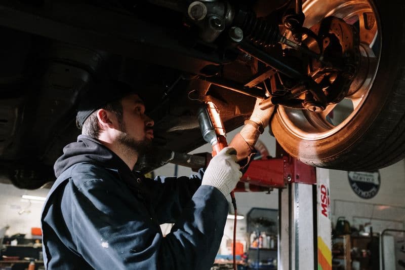 Mechanic inspecting vehicle brake components